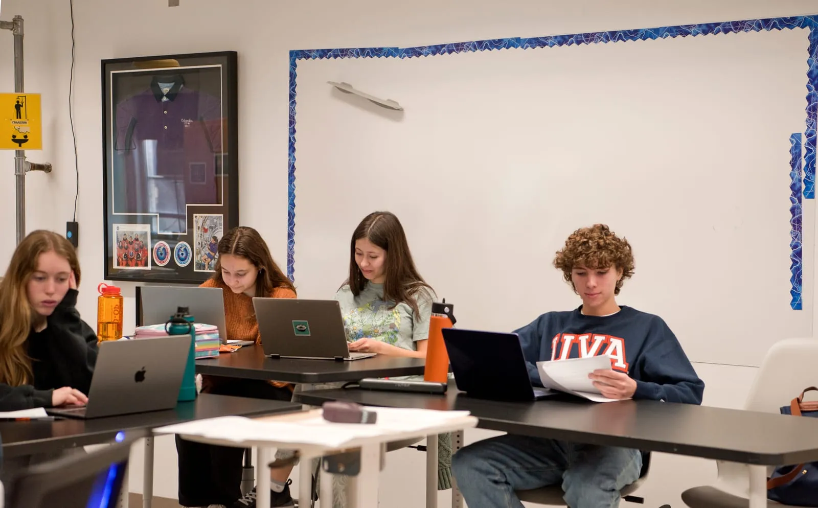 Estudiantes de secundaria trabajan con sus computadoras durante un curso de AP.
