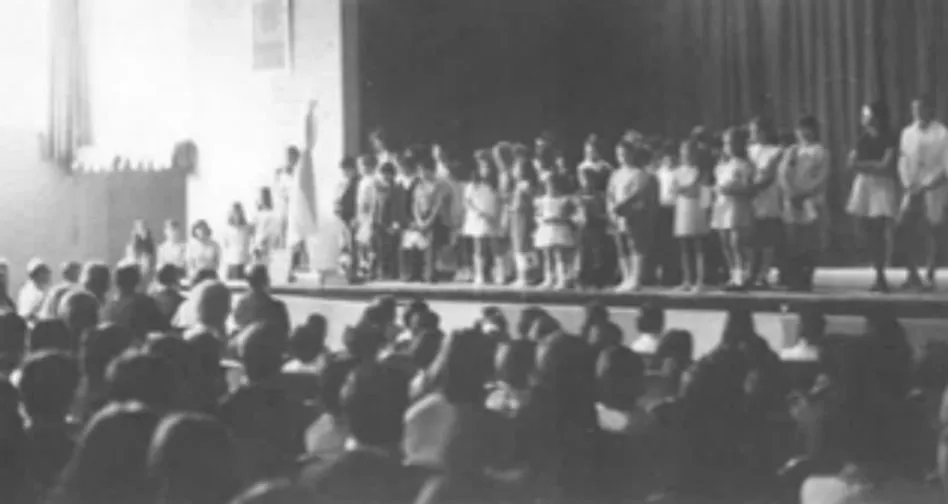 Los alumnos de la Escuela reunidos en el escenario de un salón de actos en 1973.